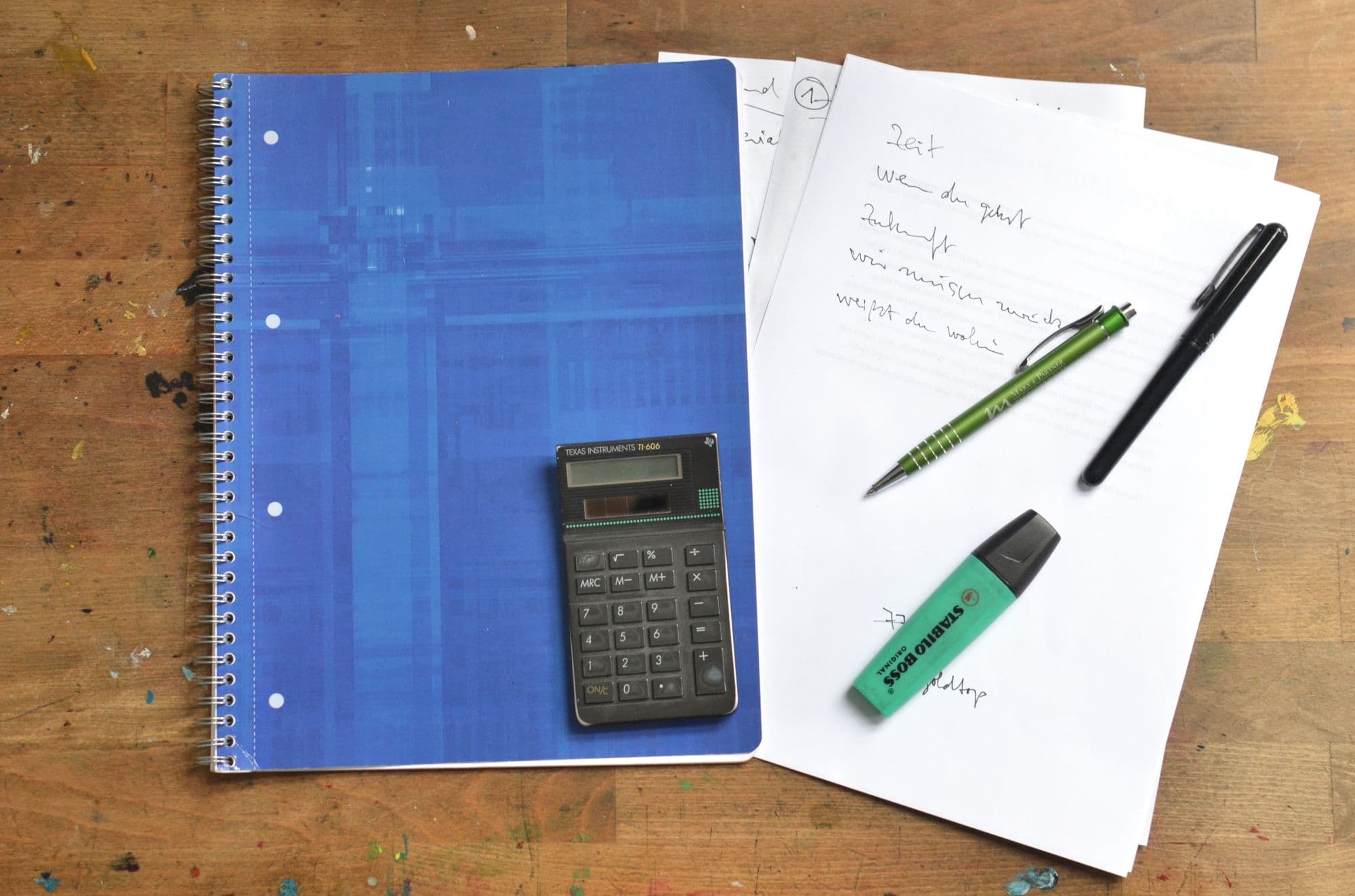 Blue notebook, calculator, and planning materials on a desk