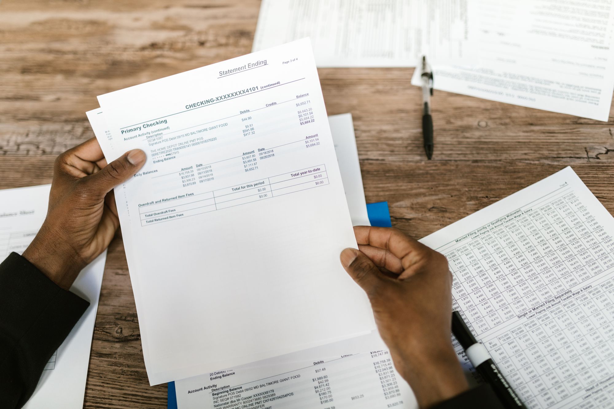 Two people going over prepared documents at a desk